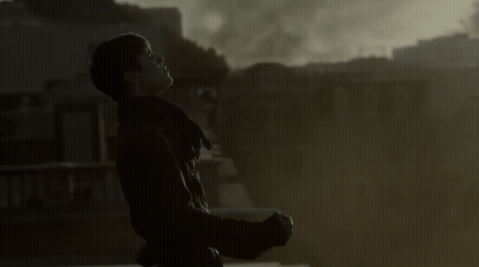a man standing in front of a large factory filled with smoke