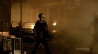 two people standing in a dark room with a fire in the background