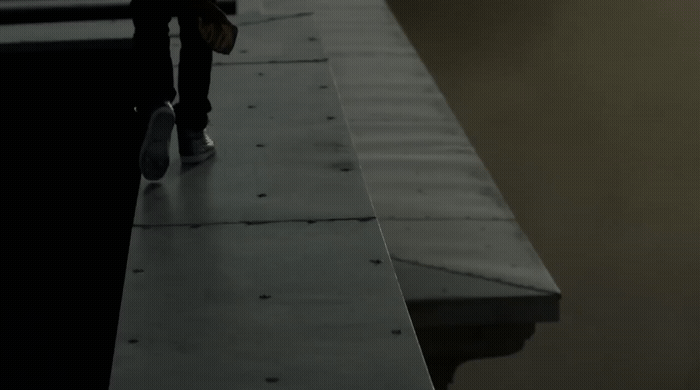 a person standing on a ledge with a skateboard