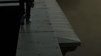 a person standing on a ledge with a skateboard