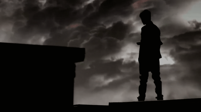 a man standing on top of a roof under a cloudy sky