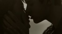 a black and white photo of a man kissing a woman
