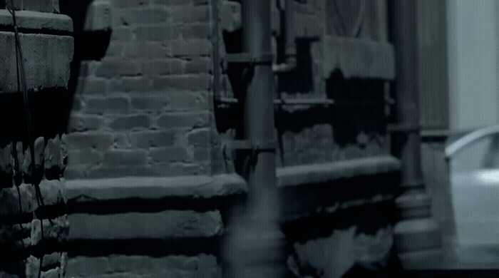 a white car parked next to a brick building