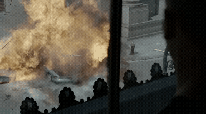 a man looking out a window at a large fire