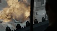 a man looking out a window at a large fire
