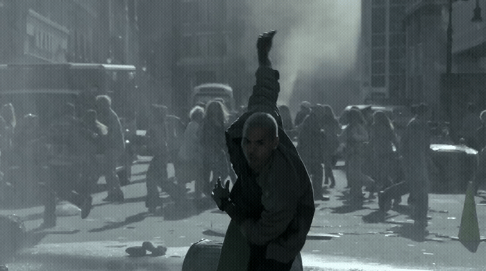 a man holding a suitcase in the middle of a street