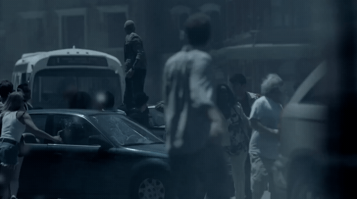 a group of people standing around a car in the rain