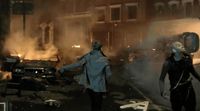 a couple of people walking down a street next to a fire
