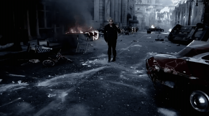 a man walking down a street next to parked cars