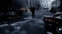 a man walking down a street next to parked cars