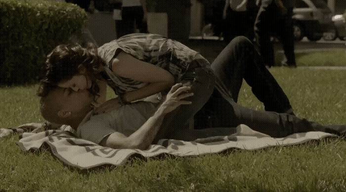 a man laying on top of a lush green field