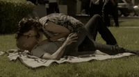 a man laying on top of a lush green field