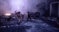 a group of people running through a street next to a fire