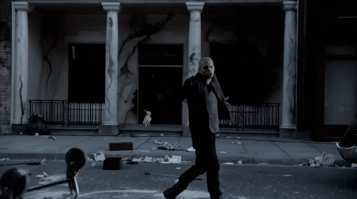 a man walking across a street in front of a building