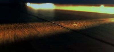 a blurry photo of a wooden floor with a light shining on it