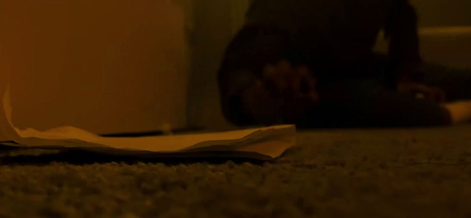 a person sitting on the floor with a piece of paper on the floor