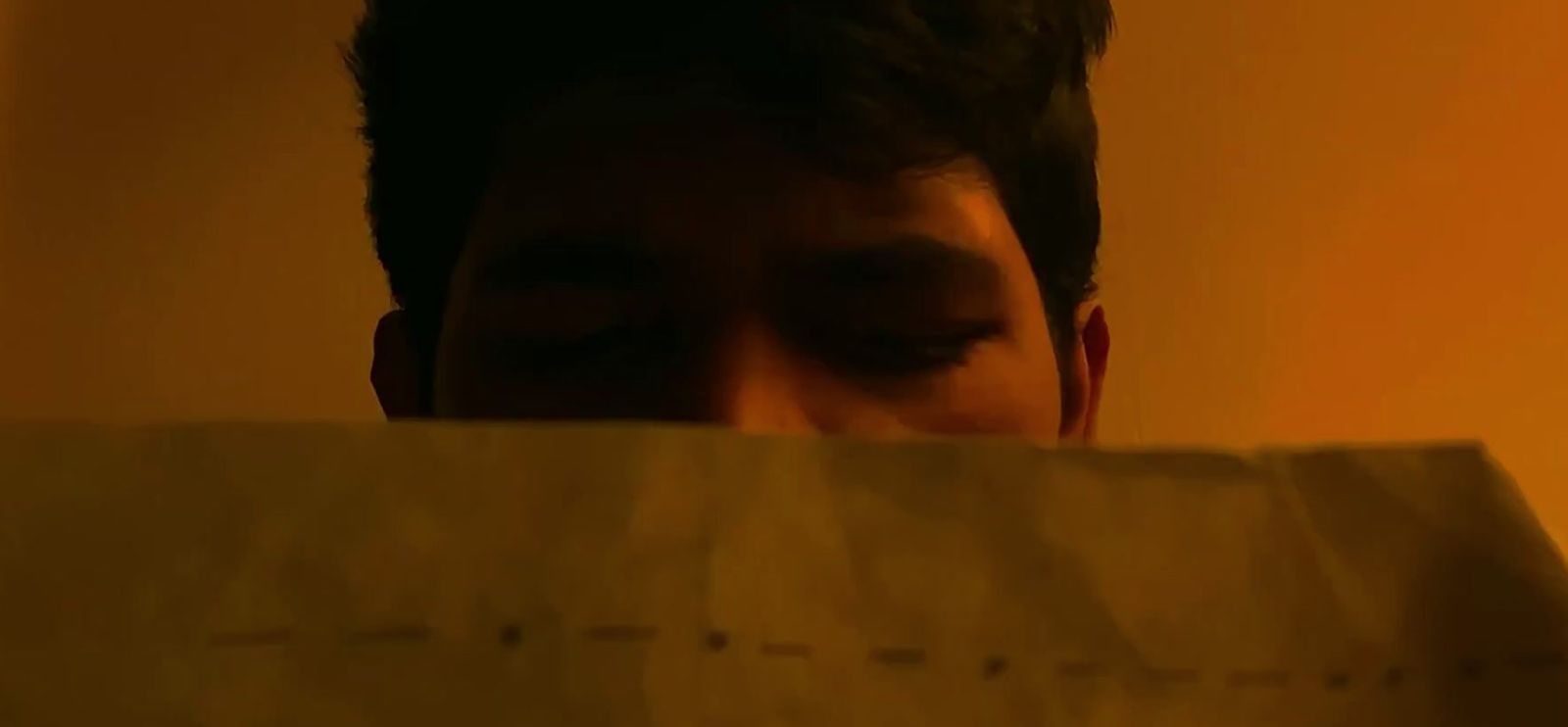 a man looking through a piece of paper