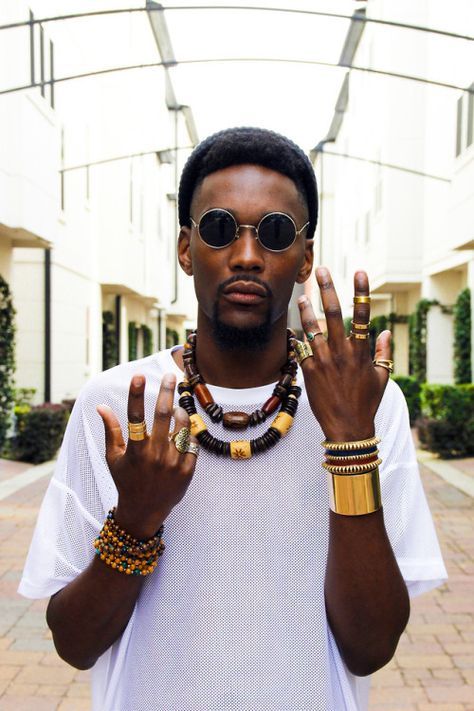 a man wearing a white shirt and some bracelets