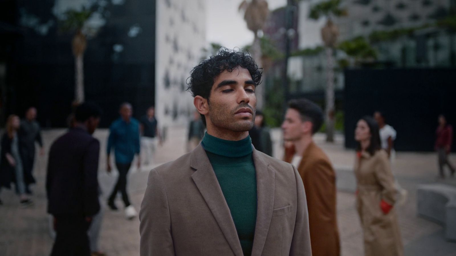 a man in a suit standing in front of a group of people