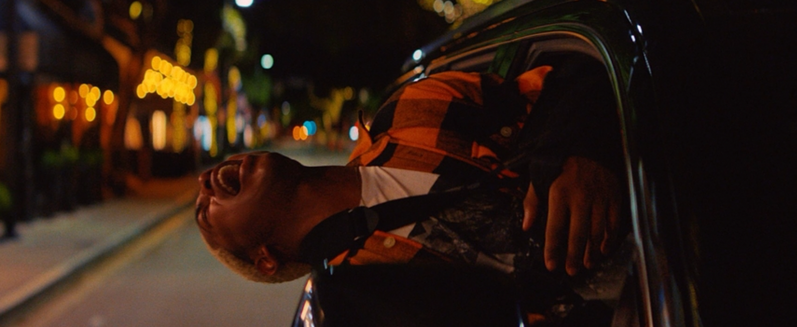 a man with his head out the window of a car