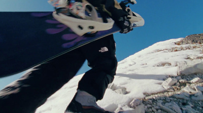 a person holding a snowboard on top of a snow covered slope