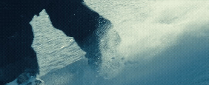 a man riding a snowboard on top of a wave