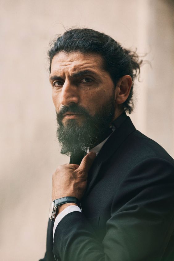 a man with a beard and a watch on his wrist