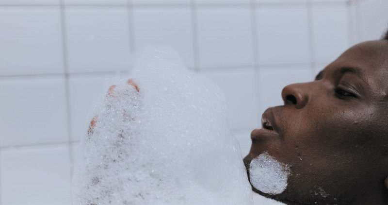 a man is taking a bath with foam on his face