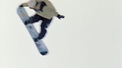 a man flying through the air while riding a snowboard