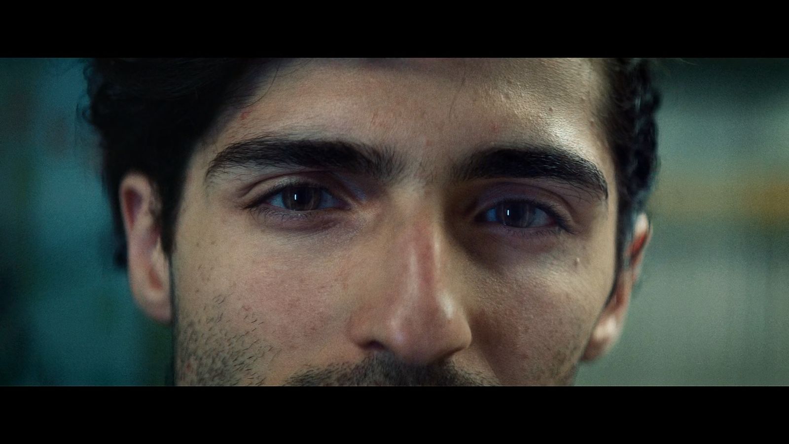 a close up of a man's face with blue eyes