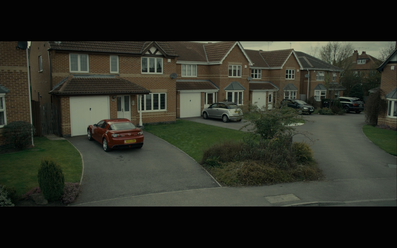 a red car parked in front of a row of houses