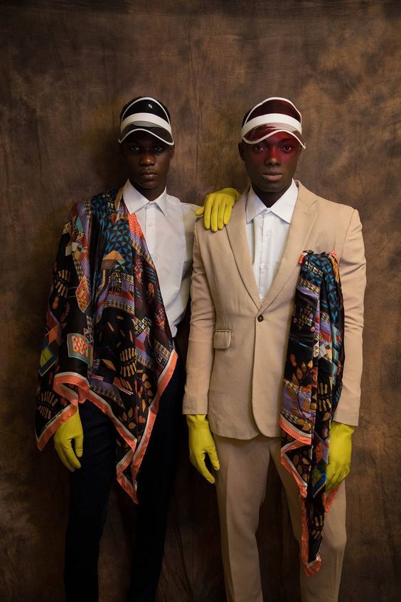 two men dressed in suits and yellow gloves