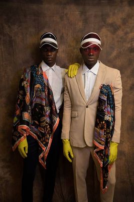 two men dressed in suits and yellow gloves