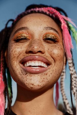 a woman with freckled hair and gold eyeshades