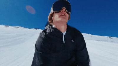 a man in black jacket standing on a snow covered slope