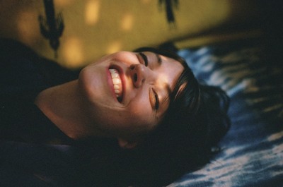 a woman laying on a bed with her eyes closed