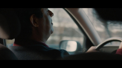 a man driving a car in a parking lot