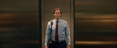 a man standing in front of a wall with a camera