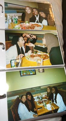 a group of people sitting around a table eating pizza