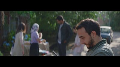 a man looking at his cell phone in front of a group of people