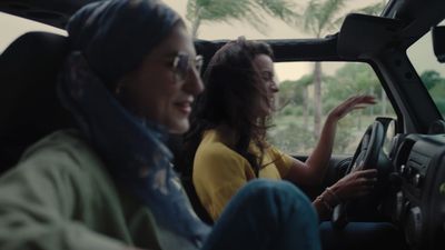 a couple of women sitting inside of a car