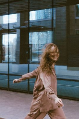 a woman walking down a sidewalk next to a building