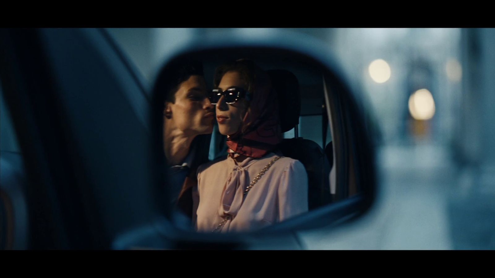 a man and a woman are seen in the rear view mirror of a car