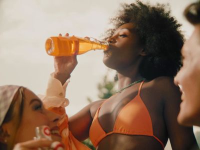 a woman in a bikini drinking from a bottle