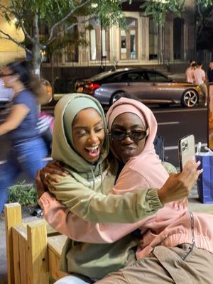 two women hugging each other on a bench