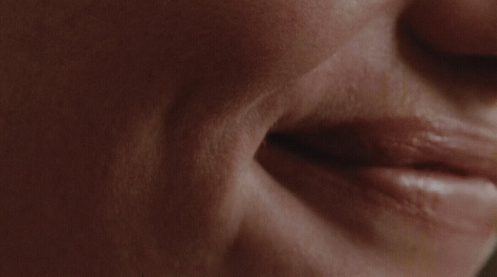 a close up of a woman's face with a toothbrush in her mouth