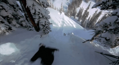 a man riding a snowboard down a snow covered slope