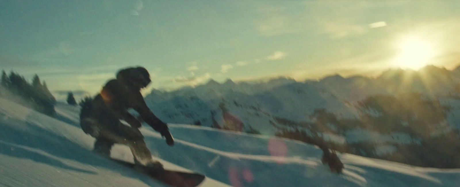 a man riding a snowboard down a snow covered slope