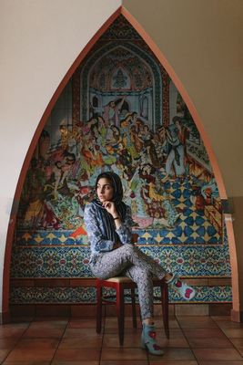 a woman sitting on top of a wooden chair