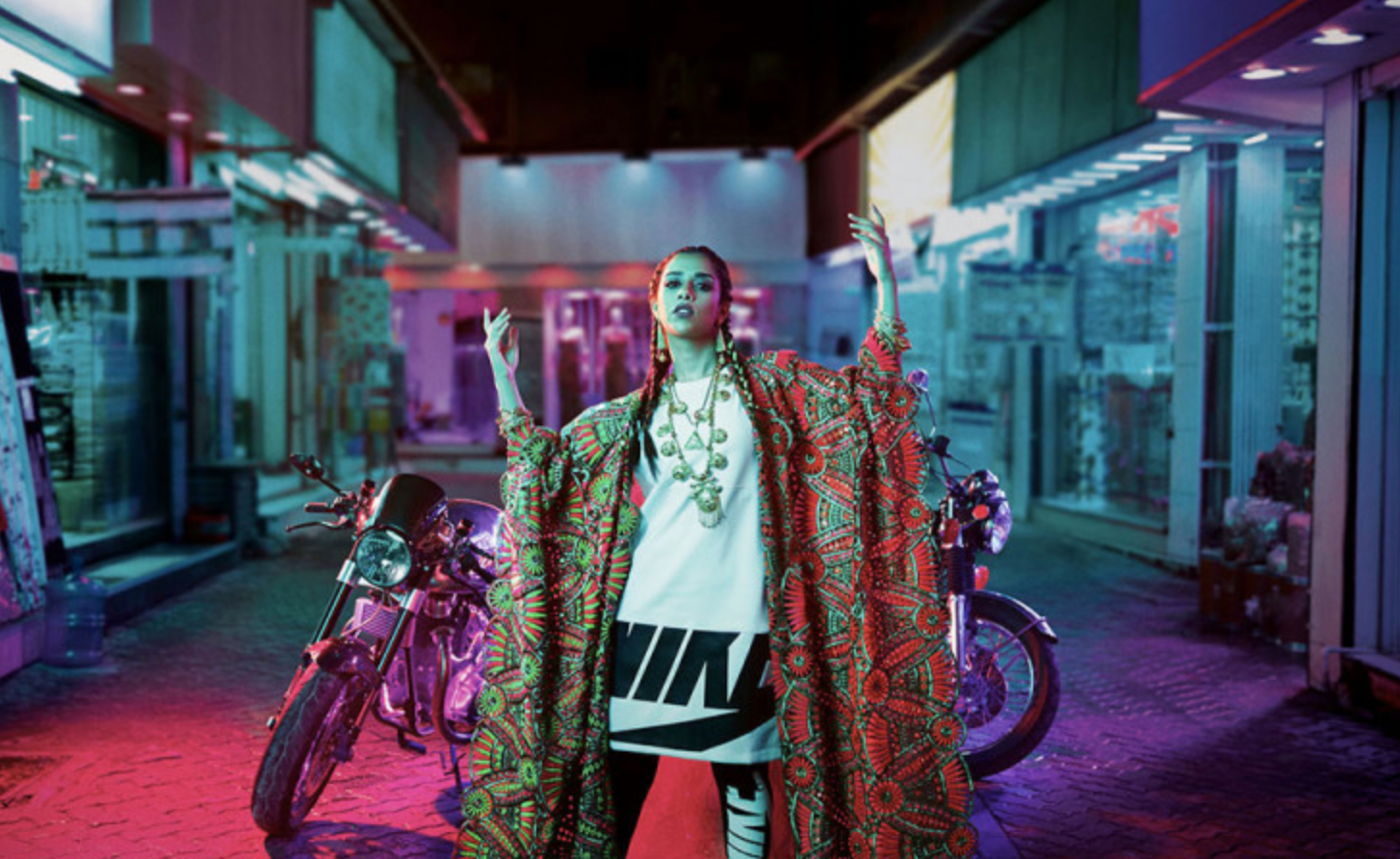 a woman standing in a room with a motorcycle